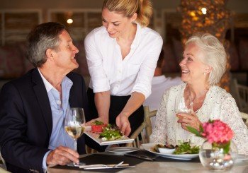 Waitress Serving Food To Senior Couple In Restaurant during a bridge tournament