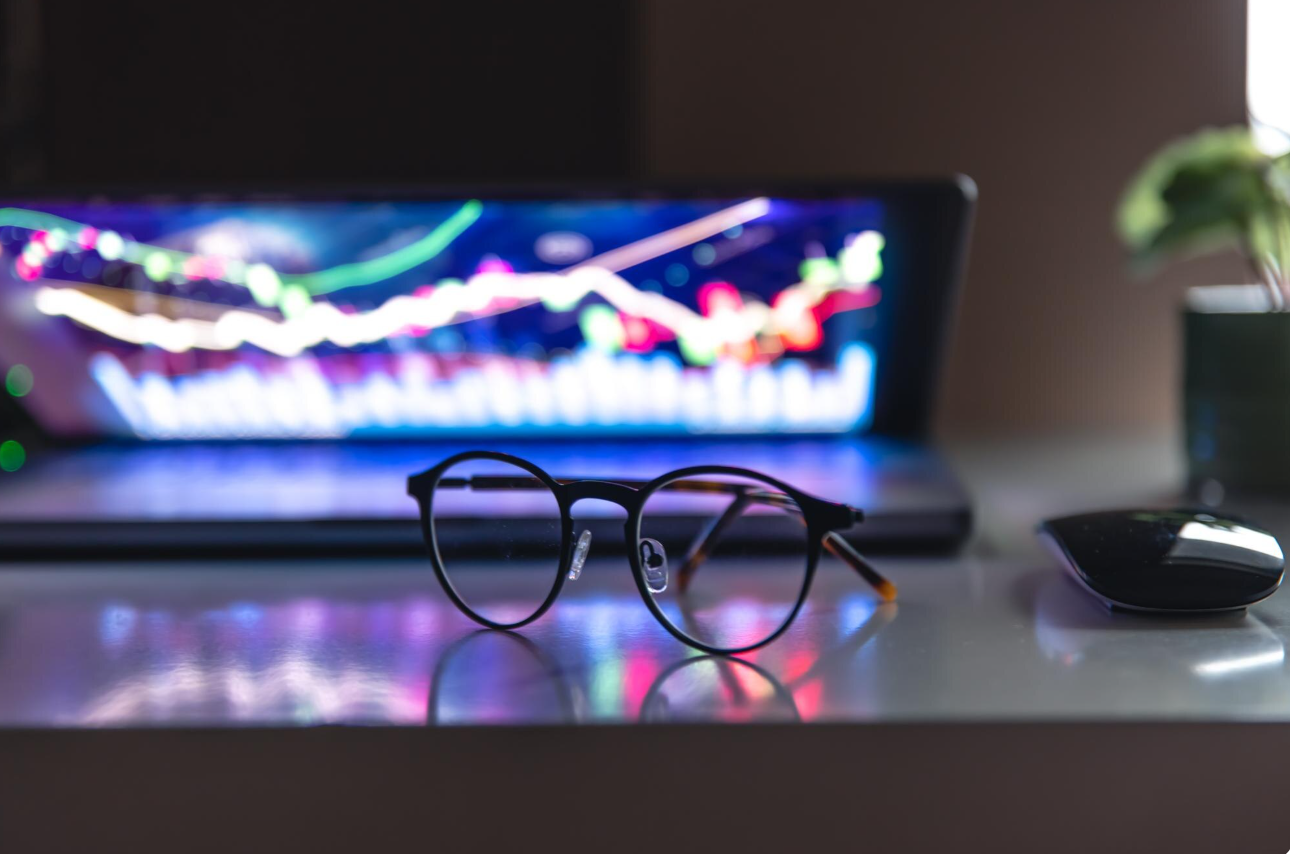 Photo of a laptop with electronic light pattern on the screen and eyeglasses in the foreground to illustrate an article titled 5-Affordable Casino Platforms for Entrepreneurs