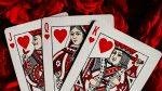 Photo of the Jack, Queen and King of hearts playing cards placed on a red plush background for article titled How Aggregators Expand Table-Game Choices for Card Fans