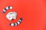 Red background, playing cards and poker chips placed to the left to illustration a story titled The Types of Card Games You Will Find in Casinos